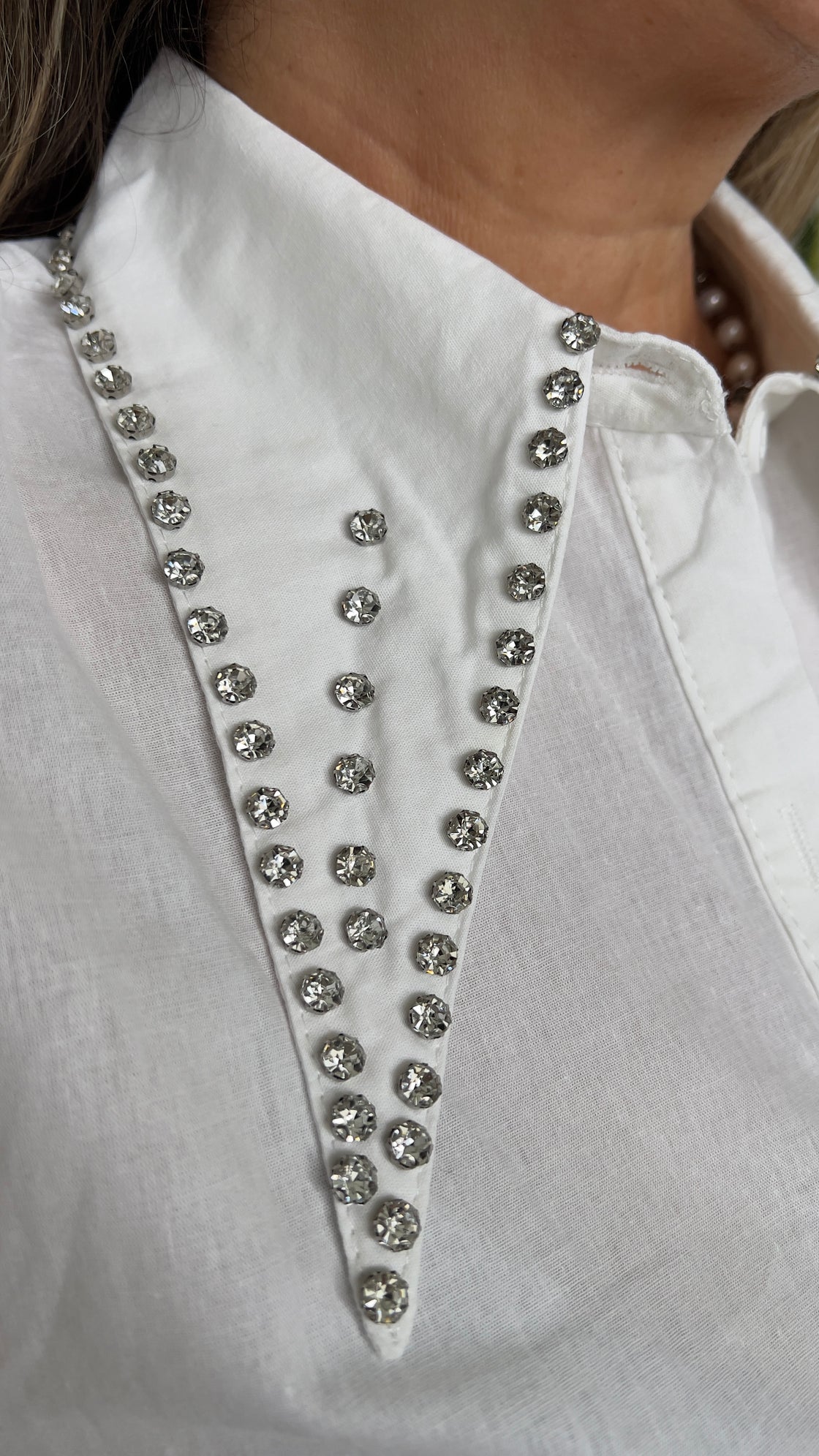 white shirt with strack details on its collar